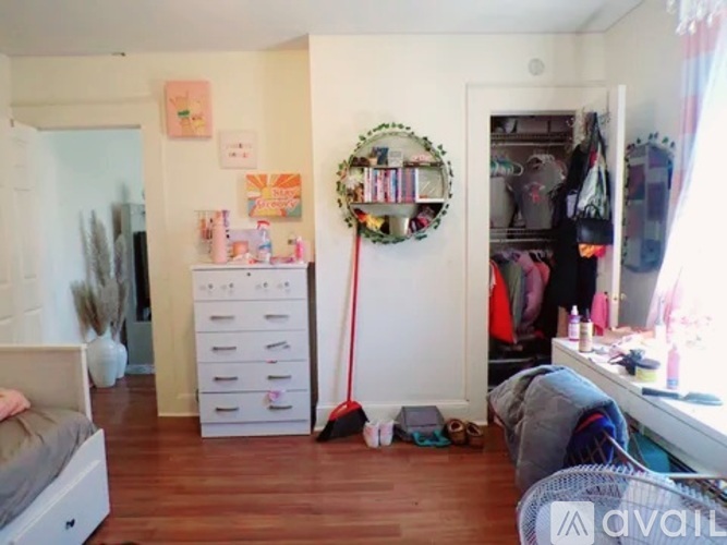 A room with a mirror, a dresser, and a bed.