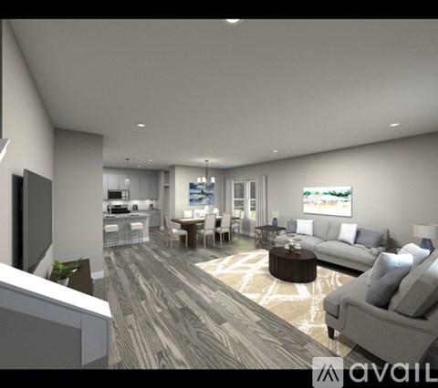 A modern living room with a grey sofa and a wooden floor.