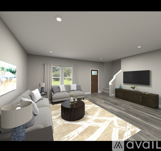 A modern living room with a grey sofa, a coffee table, and a flat-screen TV mounted on the wall.