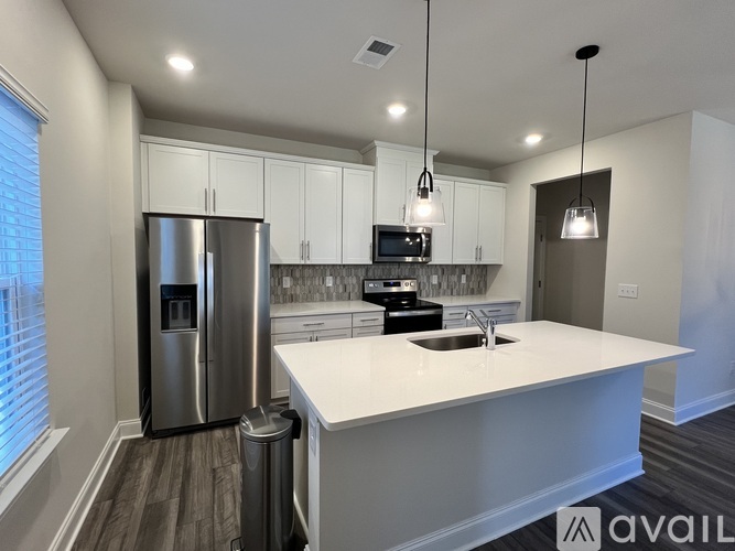 A kitchen with a white countertop and a stainless steel refrigerator.