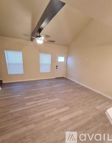 A room with wooden flooring and a ceiling fan.