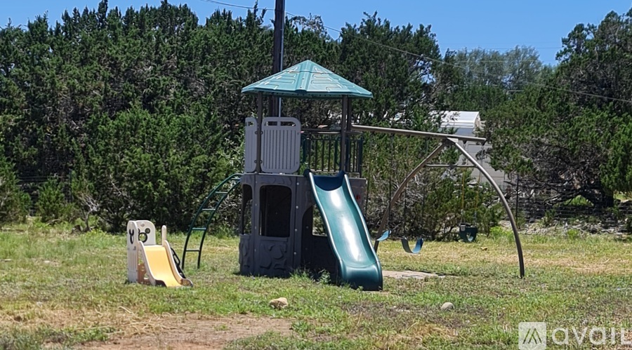 A playground with a green slide and a small tower-like structure.