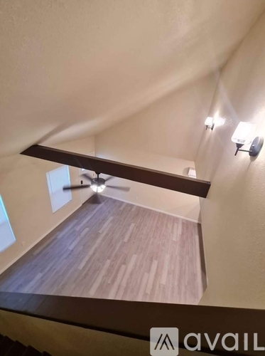A room with a wooden floor and a ceiling fan.