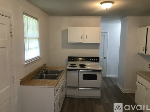 A small kitchen with white appliances and wooden countertops.