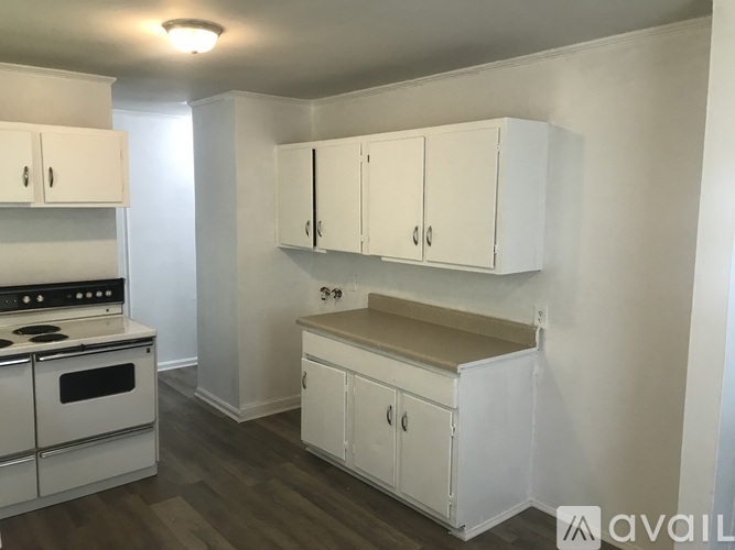 A kitchen with white cabinets and a stove top oven.
