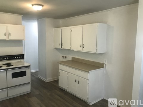 A kitchen with white cabinets and a stove top oven.