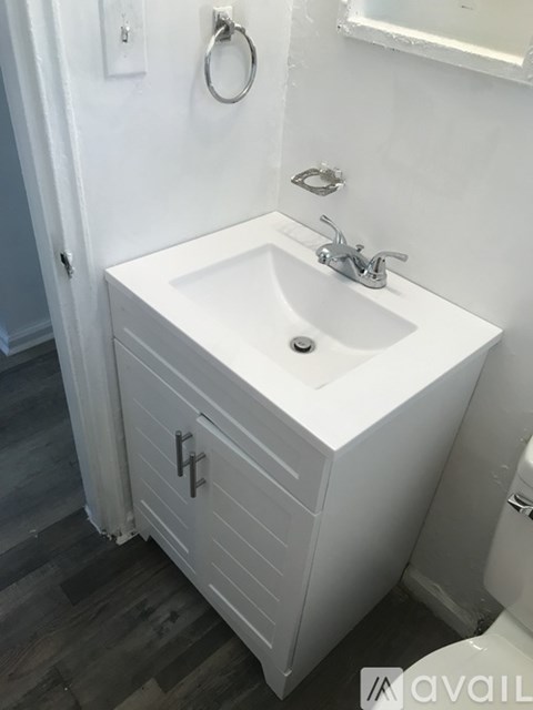 A white sink in a bathroom with a mirror above it.
