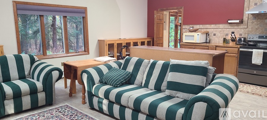A living room with a striped couch and matching chairs.