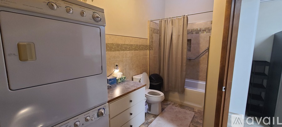 A small kitchen with a white oven and a toilet.
