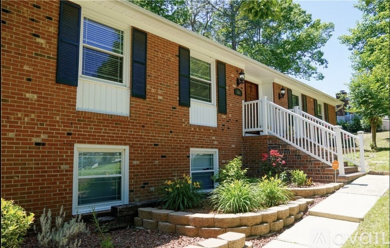 A brick house with a white porch and black shutters.