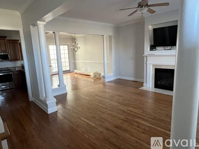 A spacious living room with wooden floors and a fireplace.