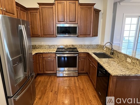 A kitchen with wooden cabinets and a granite countertop.