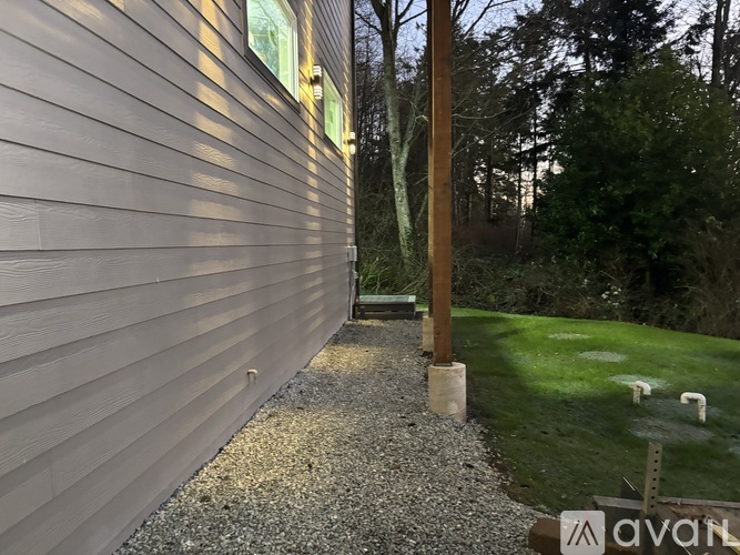 A gravel path leads from a house to a grassy area.