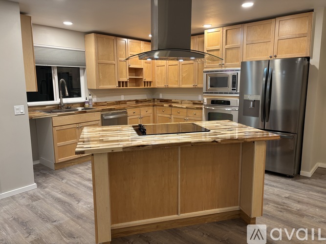A kitchen with wooden cabinets and a wooden island.