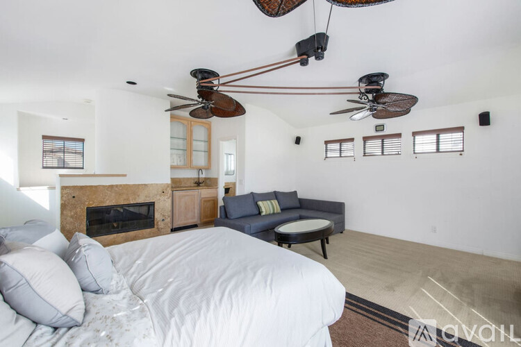 A bedroom with a large bed and a fireplace.