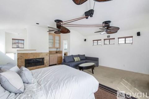 A bedroom with a large bed and a fireplace.