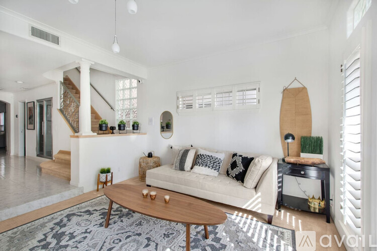 A living room with a white couch and a wooden coffee table.