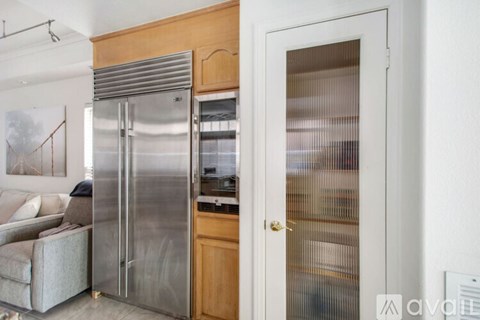 A modern kitchen with a stainless steel refrigerator and wooden cabinets.