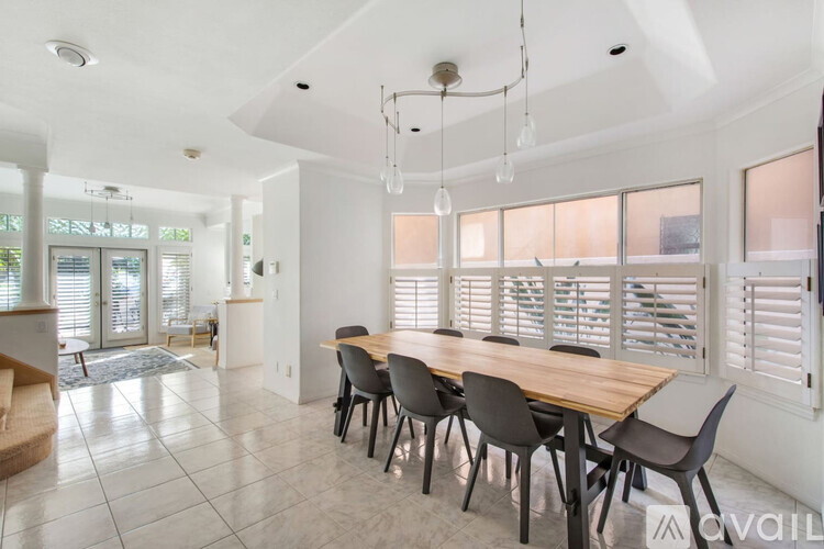 A dining room with a long table and chairs.