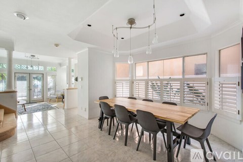 A dining room with a long table and chairs.