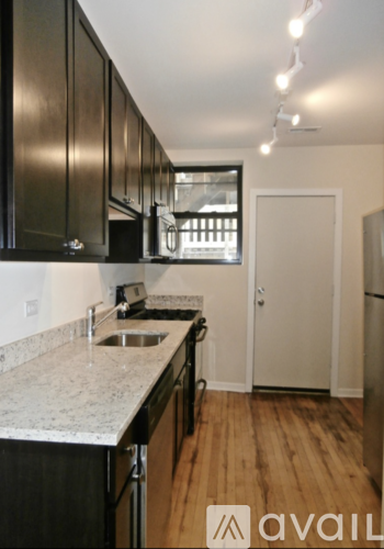 A kitchen with black cabinets and a sink.