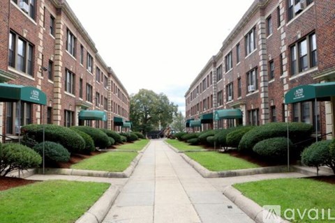 A long, straight road separates two rows of identical buildings.