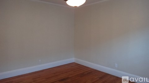 A room with wooden flooring and a light on the ceiling.