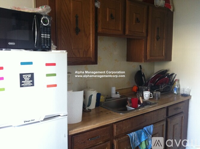 A kitchen with a white fridge and wooden cabinets.