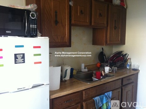 A kitchen with a white fridge and wooden cabinets.