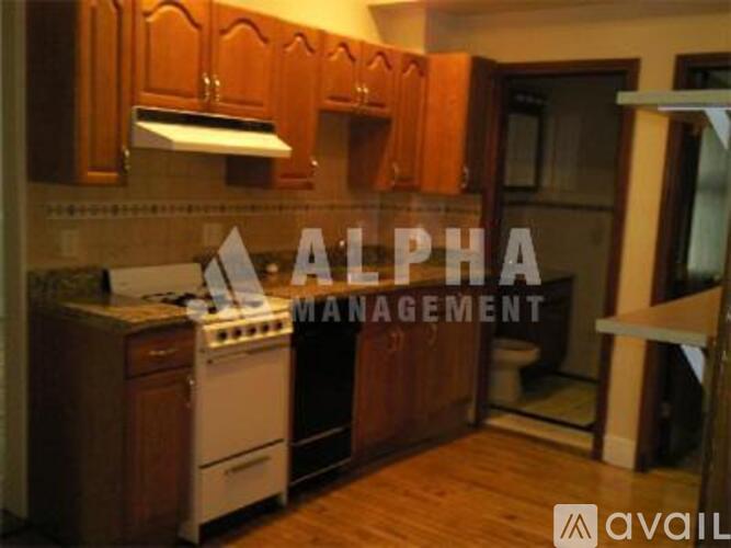 A kitchen with wooden cabinets and a white stove top oven.