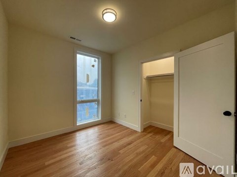 A room with wooden floors and a window overlooking a cityscape.