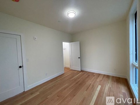 A room with wooden flooring and two doors.