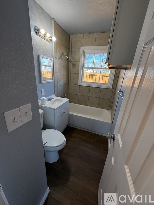 A bathroom with a toilet, sink, and bathtub.