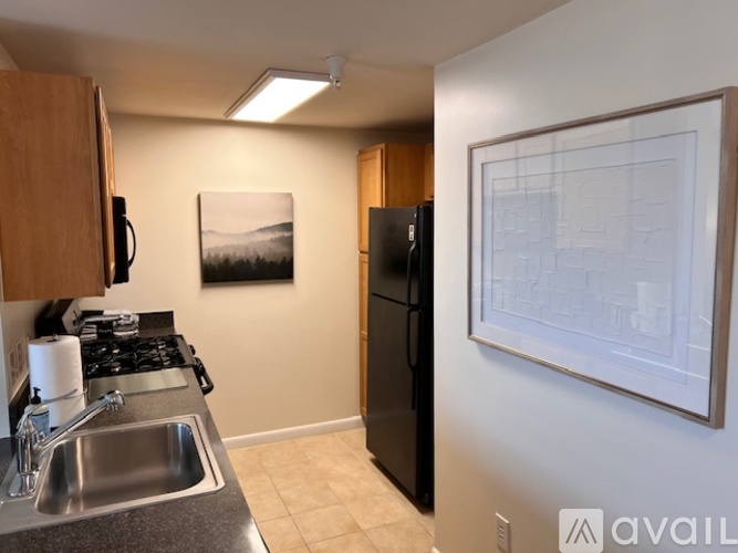 A kitchen with wooden cabinets and black appliances.