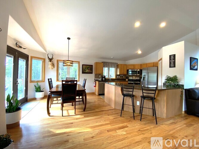A modern kitchen with wooden floors and a dining table with chairs.