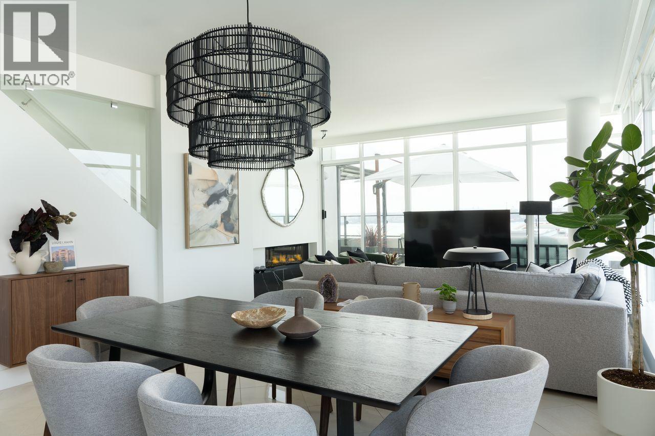 A modern dining room with a black table and grey chairs.