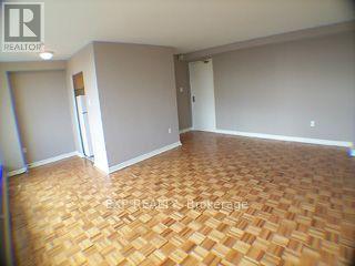 A room with wooden flooring and a doorway leading to another room.