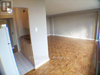 A room with wooden flooring and a white wall.