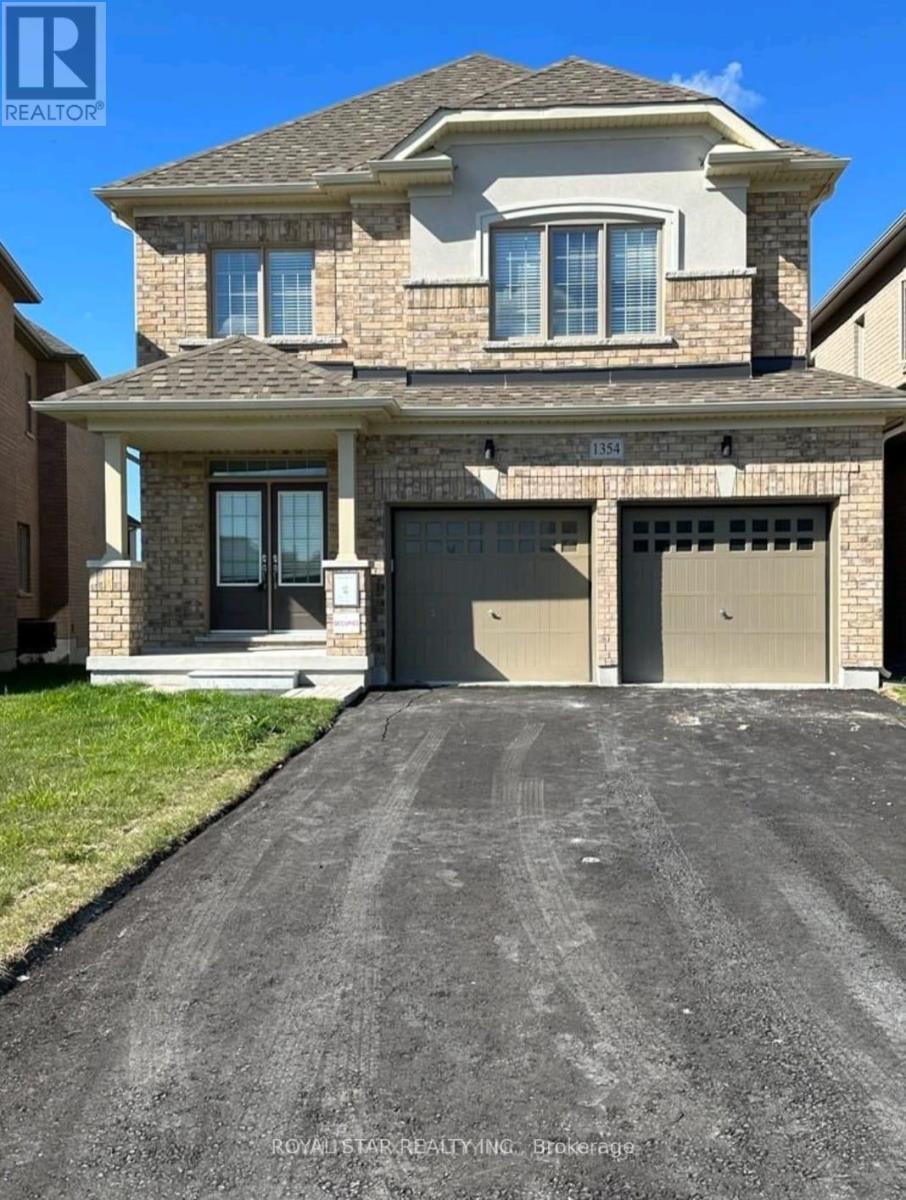 A house with a garage and a driveway in front of it.