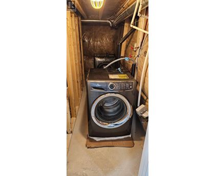 A black washing machine in a small, enclosed space.