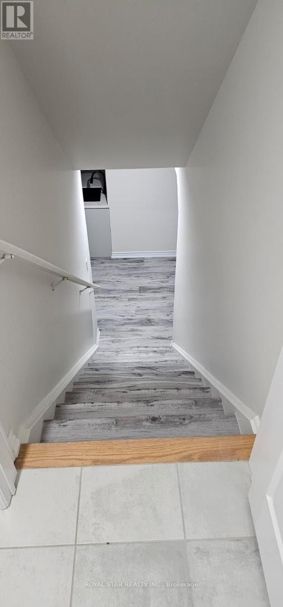 A hallway with a wooden floor and white walls.