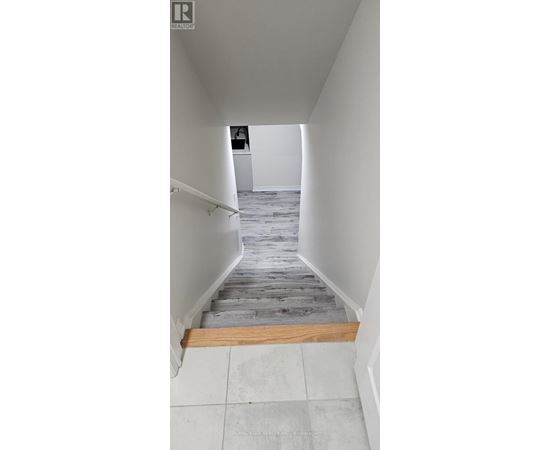 A hallway with a wooden floor and white walls.