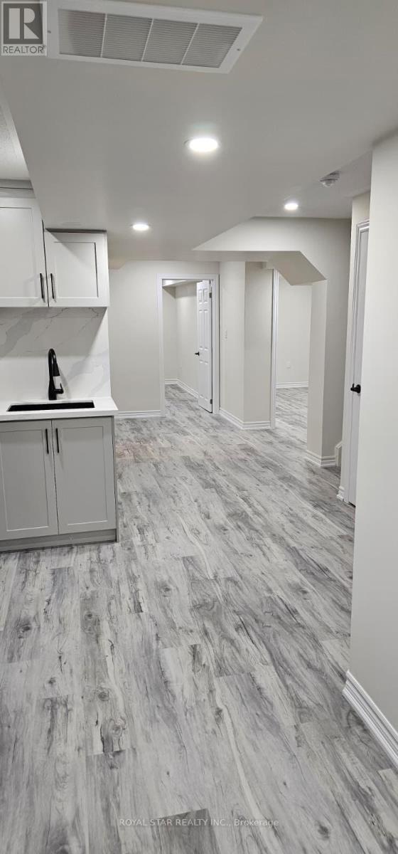 A kitchen with white cabinets and a wooden floor.