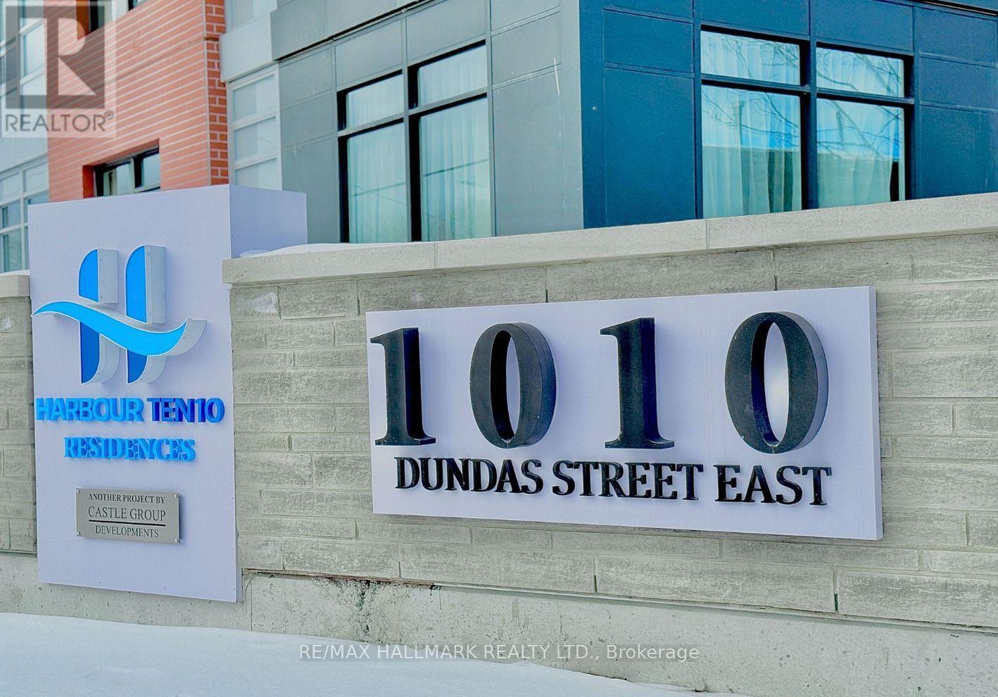 A sign for a realtor company stands in front of a building.