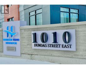 A sign for a realtor company stands in front of a building.