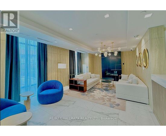 A spacious living room with a blue chair and a white couch.