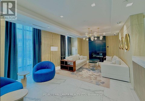 A spacious living room with a blue chair and a white couch.