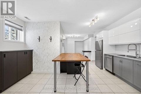 A kitchen with a table and chairs in the middle.