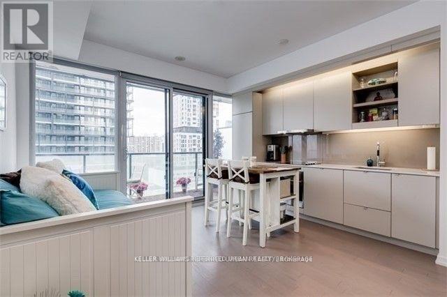 A well-lit kitchen with a dining table and chairs.