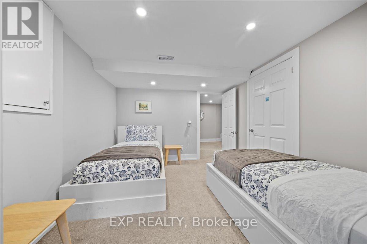A bedroom with two beds and a desk.